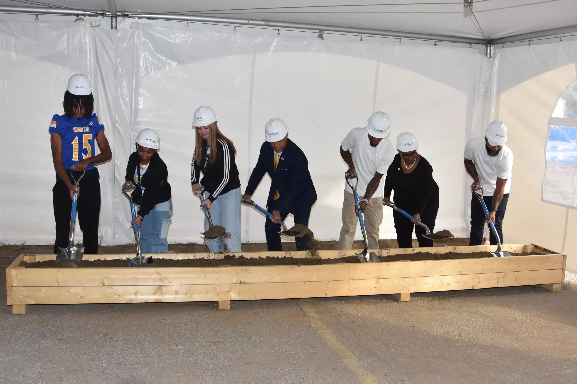 Image of 7 people participating in a ceremonial ground breaking