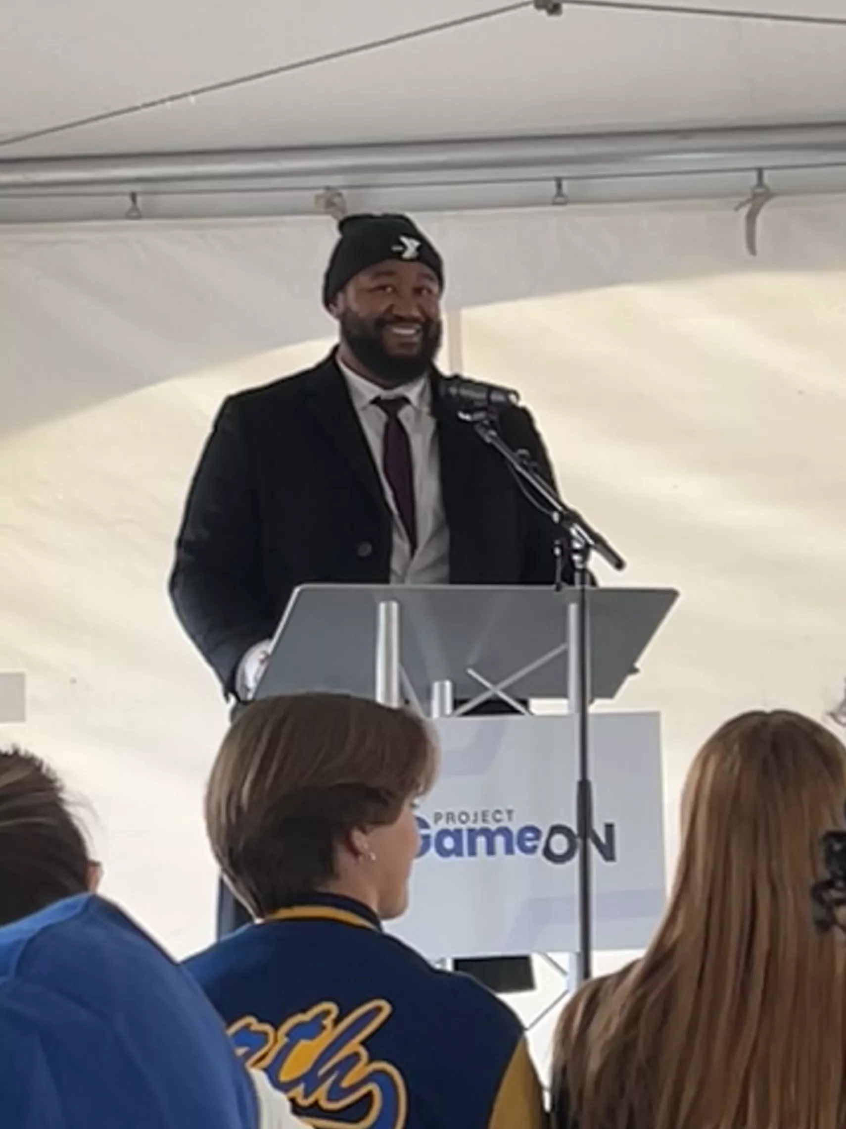 DeValon Whitcomb speaking at a podium during a groundbreaking
