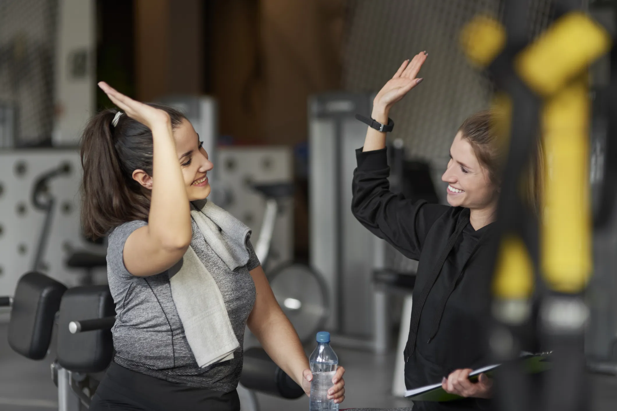two women high fiving in the gym