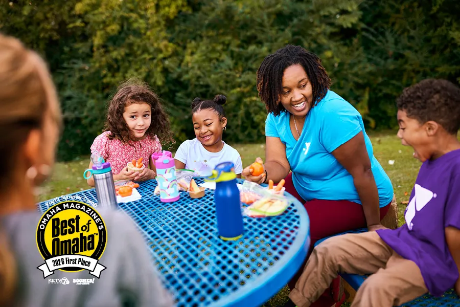 Kids eating lunch at camp with their counselor