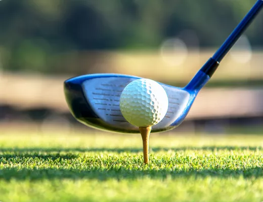 Close up image of a golf club and ball