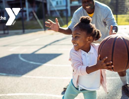 girl playing basketball with family