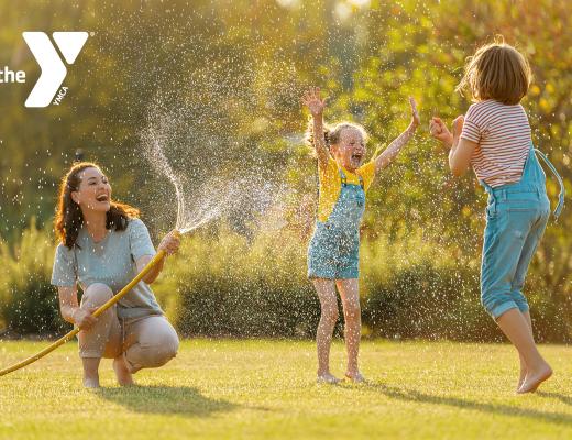 Family getting sprayed with a hose outdoors