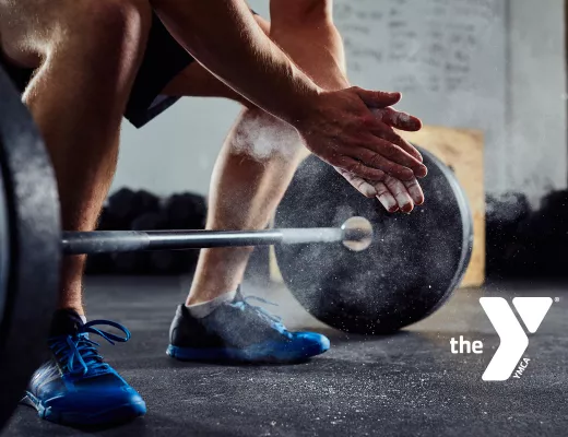 Closeup of a man's hands and lower body as he is about to deadlift.