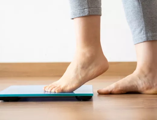 A woman's feet about to step on a scale