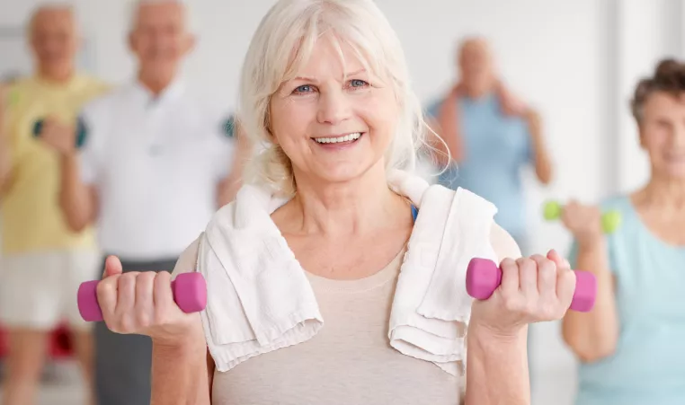 Active Older Adult with weights and towel