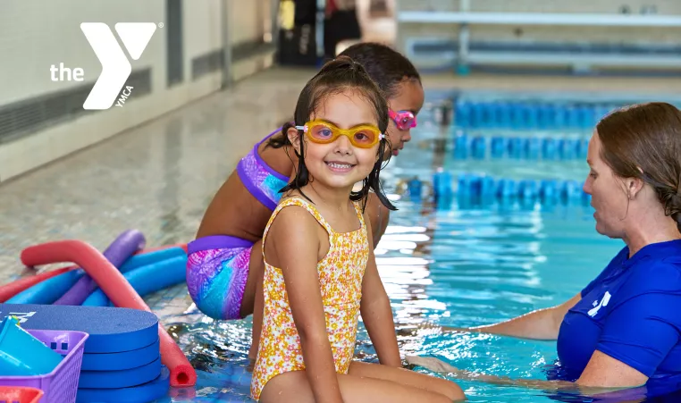 Young girl sitting on the edge of a pool