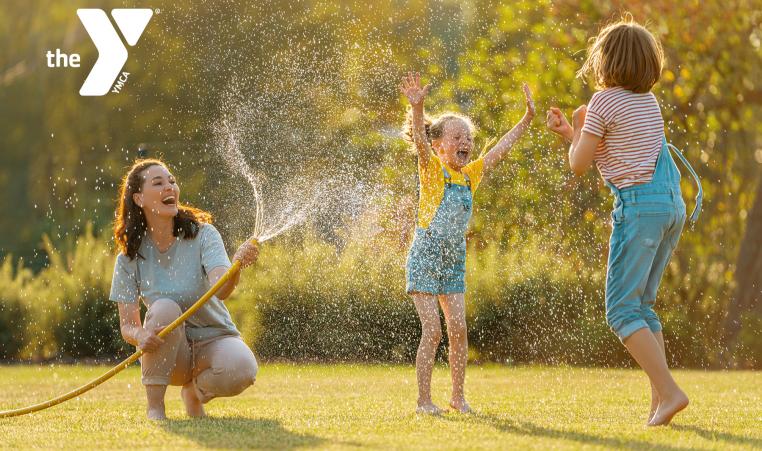 Family getting sprayed with a hose outdoors