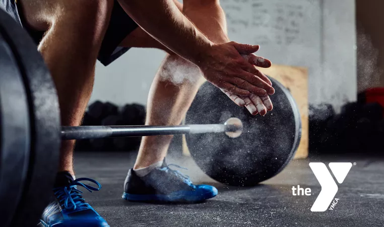 close up of a man ready to deadlift a weighted bar