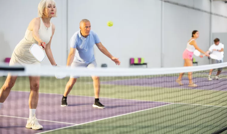 A couple playing pickle ball indoors
