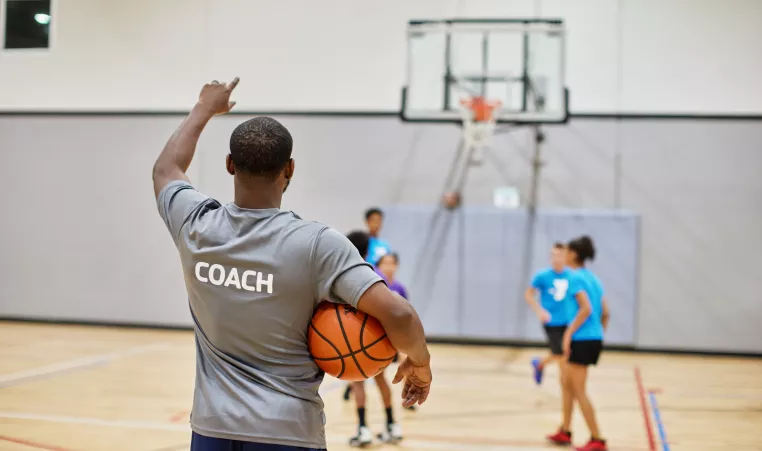 Image of man coaching youth basketball