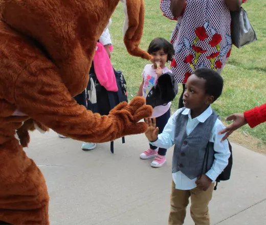 Child giving a mascot a high five