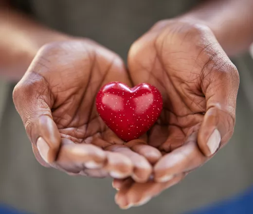 Women's hands holding a heart shape