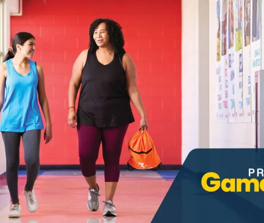 Two women walking on an indoor track
