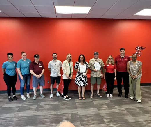 A group of people posing for a shot with 2 Red Cross award winners