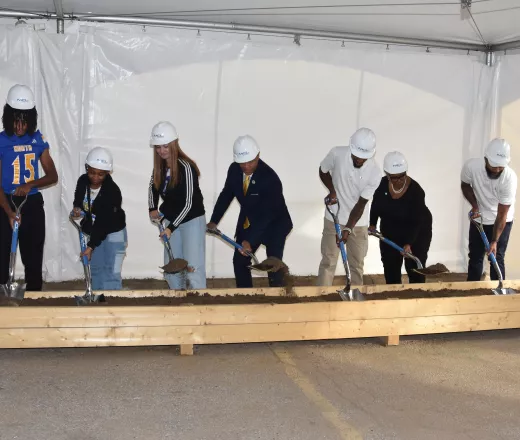 Image of 7 people participating in a ceremonial ground breaking