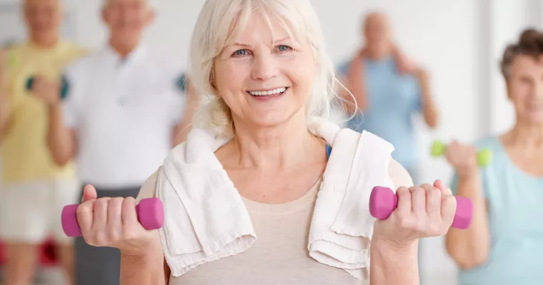 Active Older Adult with weights and towel