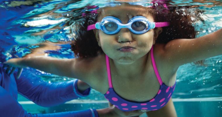 Young girl practicing swimming underwater
