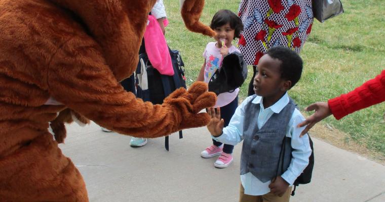 Child giving a mascot a high five