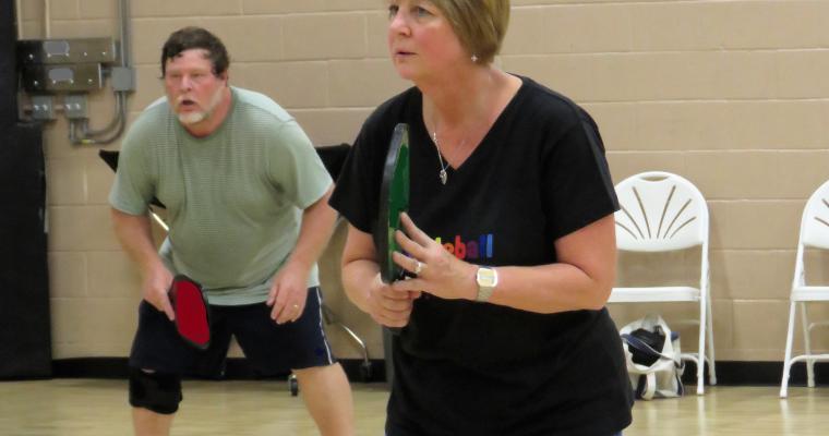 An image of two adults playing pickleball. 