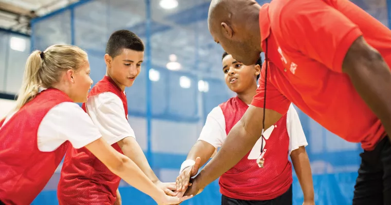 Basketball team hands in with their coach