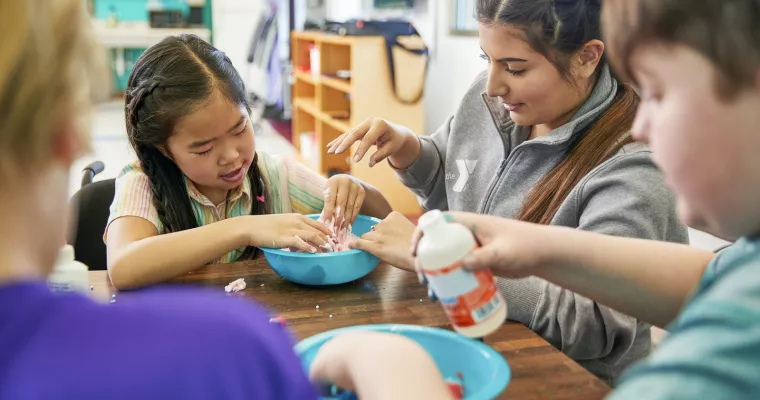 Young staff member working with kids on crafts