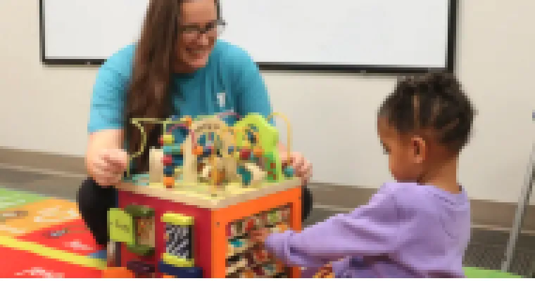woman and child playing with toy together 