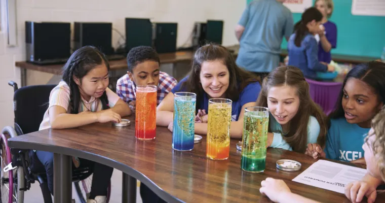 Counselor and kids doing a science experiment 