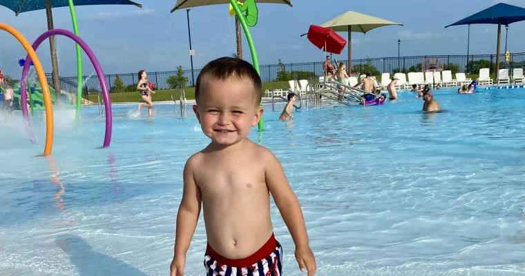 young boy standing in the water 